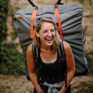 laughing woman wearing Oru Kayak Bay ST in backpack