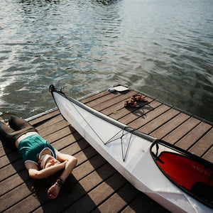 woman with Oru Kayak relaxing on wharf