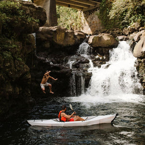 Oru Kayak Beach LT with waterfall and man jumping off cliff