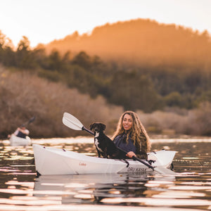 Woman with dog paddling the Oru Kayak Lake