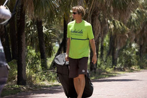 Man walking with a Pakayak Bluefin 142 in wheeled bag